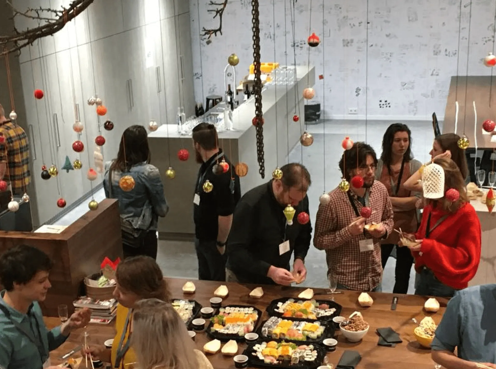 Alumni catching up around a kitchen island during a company visit